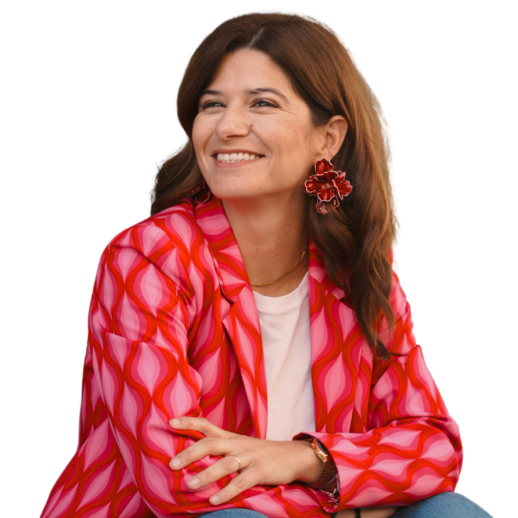 Joana Teixeira sorridente com blazer rosa e vermelho, recortada sobre fundo transparente para materiais visuais e mockups da marca.